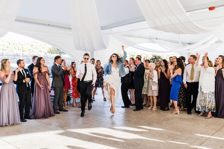 bride and groom wearing matching sunglasses dance their way into wedding reception