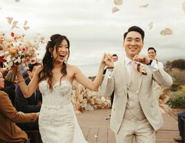 The newlyweds exit their beachside ceremony as their loved ones look on. 