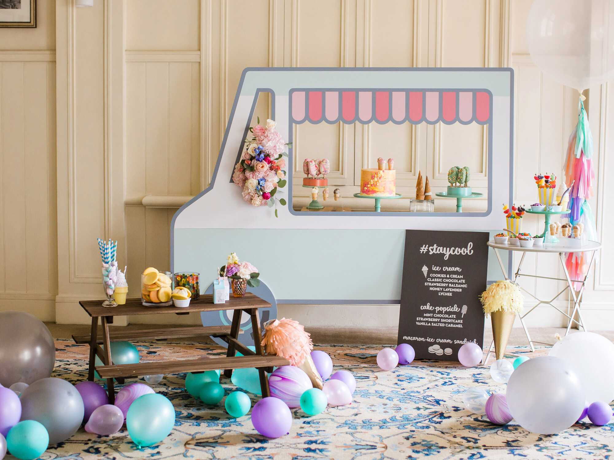 Large and small teal and purple balloons scattered in party venue