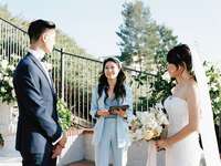 bride and groom stand outside at wedding ceremony with officiant