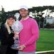 Wyndham Clark and Alicia Bogdanski holding a trophy