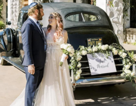 Couple in front of vintage wedding car with just married sign, Los Angeles wedding transportation