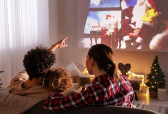 Happy couple with their child watching a holiday film