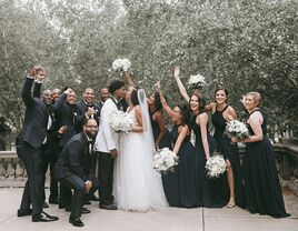 Kissing couple surrounded by their wedding party