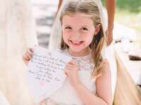 Smiling flower girl with custom handkerchief flower girl gift.