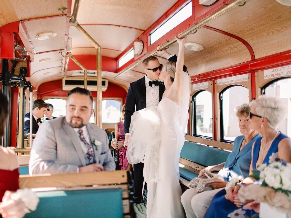 Couple kissing in the wedding trolley with a few loved ones