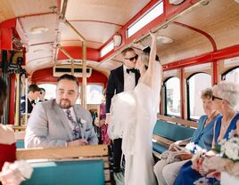 Couple kissing in the wedding trolley with a few loved ones