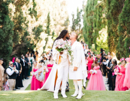 Grooms kissing at outdoor haitian-american wedding ceremony