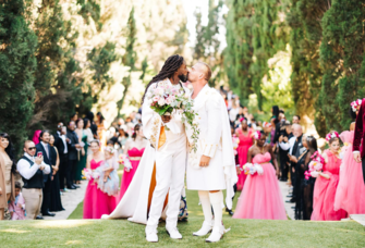 Grooms kissing at outdoor haitian-american wedding ceremony