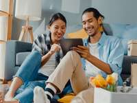 Couple laughing at a tablet looking at world records