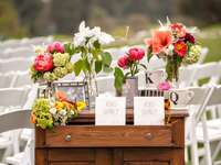 Outdoor wedding program table setup with family photos and flowers