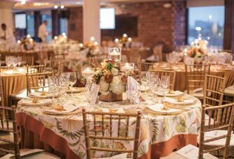 Close up of decorated event table surrounded by gold Chivari chairs