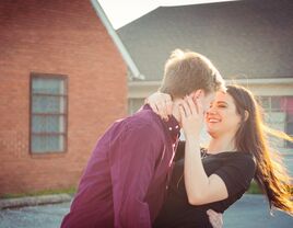 Happy couple laughing while holding onto each other