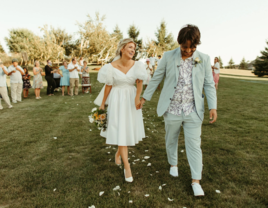 Couple holding hands and smiling at backyard wedding ceremony