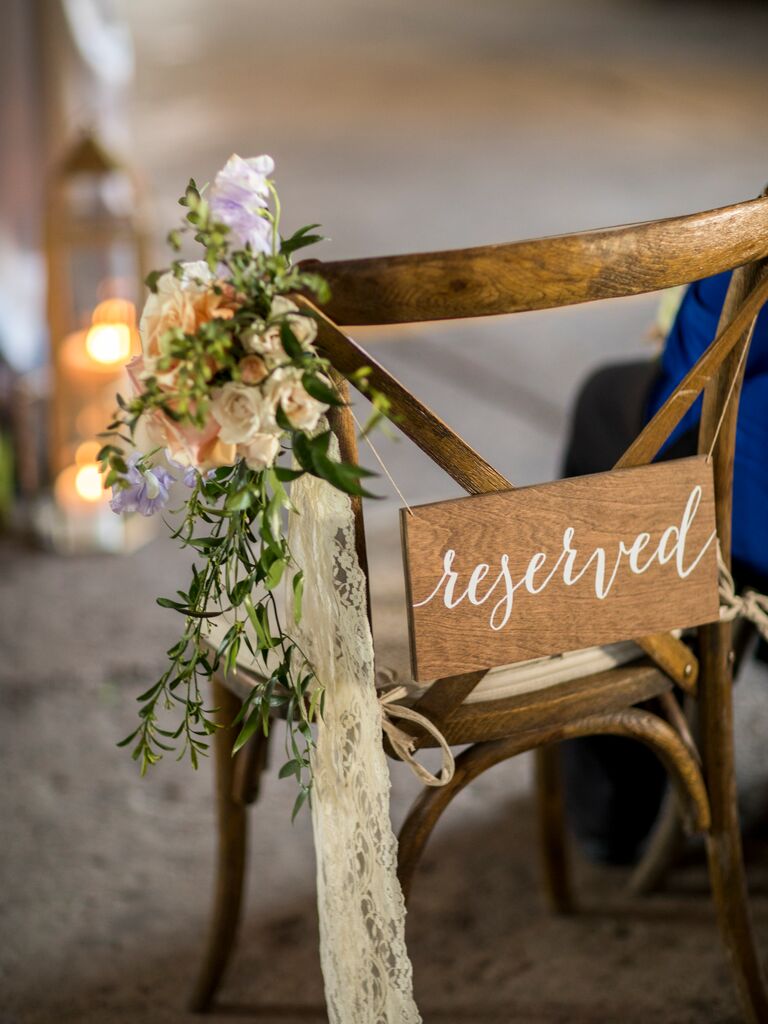 wooden cross back chair with reserved sign and small bouquet wedding aisle marker with lace ribbons