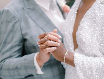 Couple holding hands on wedding day.