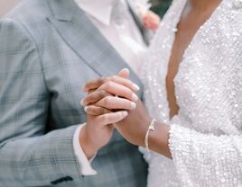 Couple holding hands on wedding day.