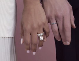 Couple holding hands, one of them wearing an engagement ring