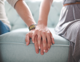 Couple holding hands on couch