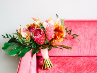 A bridal bouquet sitting on a pink couch