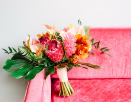 A bridal bouquet sitting on a pink couch