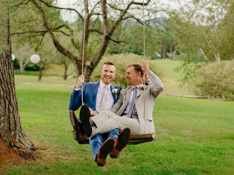 grooms on swing at rustic outdoor Vermont wedding
