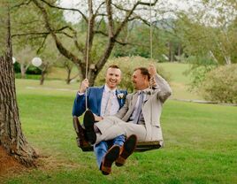 grooms on swing at rustic outdoor Vermont wedding