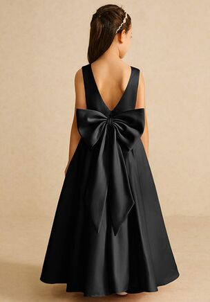 Pipsy is our classic matte satin flower girl dress. She features a scoop neckline, a V-back with a bow tie, and a pleated A-line skirt. This dress is not only perfect for a flower girl at a wedding but also versatile enough for other special occasions.