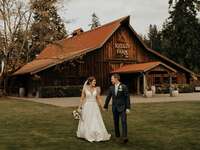 Couple holding hands outside the wooden barn venue at The Kelley Farm