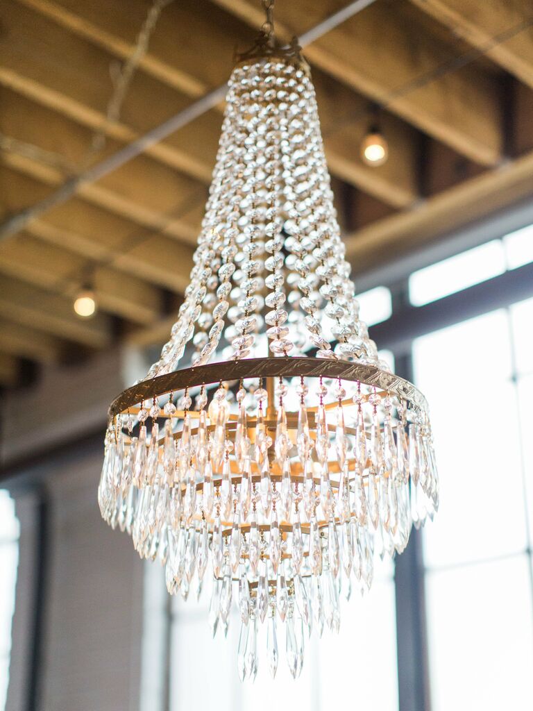 crystal chandelier hanging from ceiling at indoor wedding venue