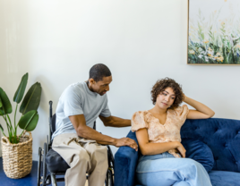 Man trying to talk to partner sitting on couch