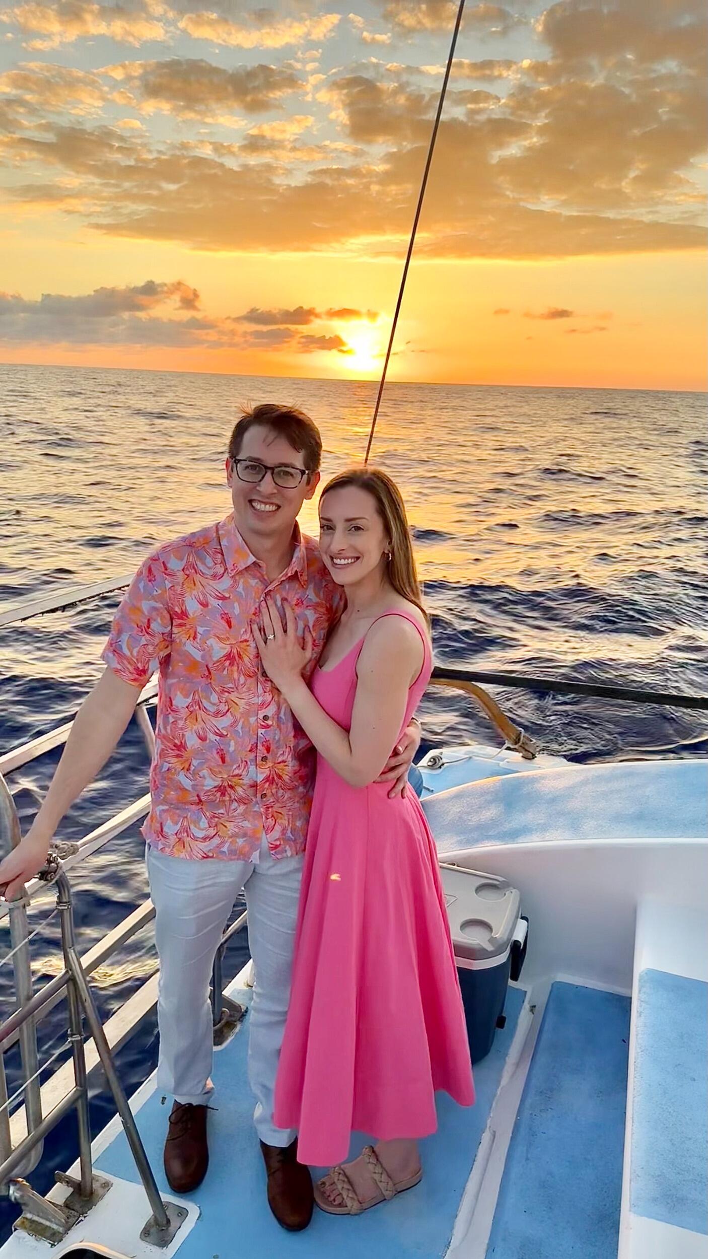 Tyler proposes to Kirsten on a private chartered sunset sail in Hawaii, surrounded by dolphins.