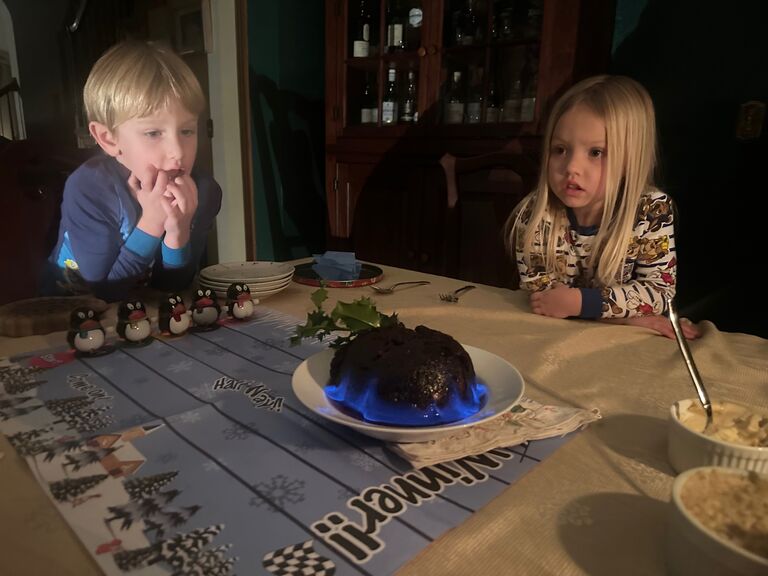 Introducing English Christmas traditions to Johnna's family. Bo and Charlotte watching the flaming Christmas pudding after opening poppers