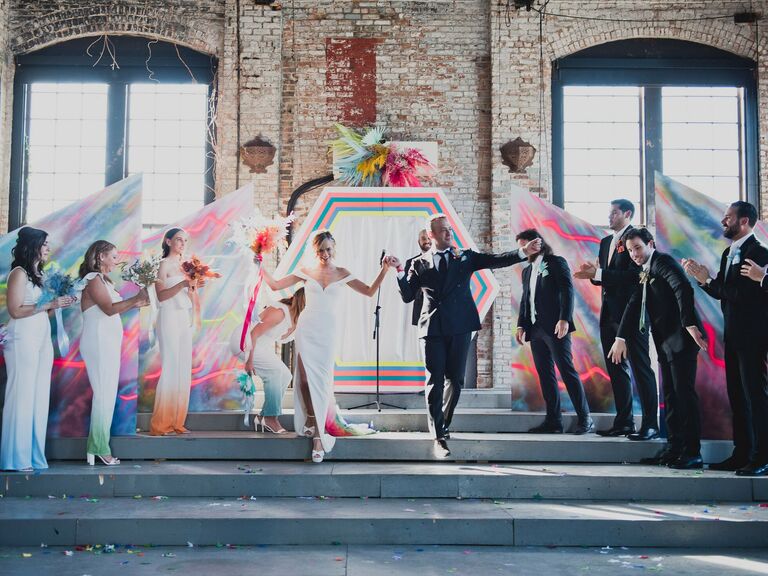 Bride in Fitted Gown With Dyed Train and Groom Walk in Recessional From Their Colorful Ceremony