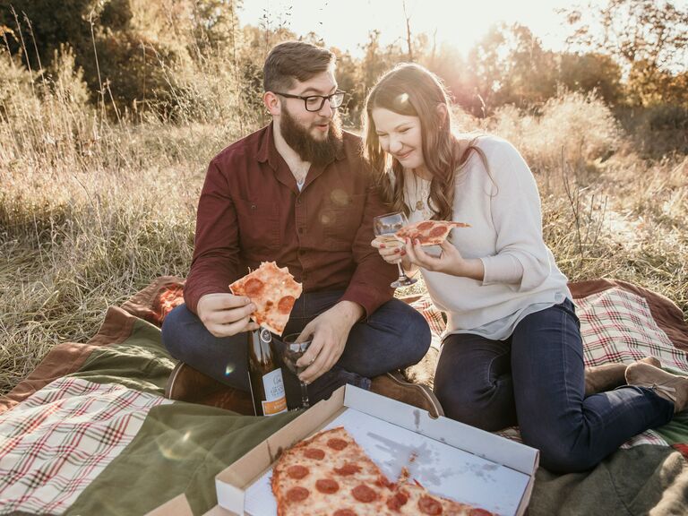 engagement photo shoot eating pizza on a picnic