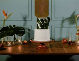 White buttercream two-tier wedding cake with banana leaf decoration