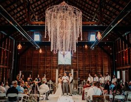 Happy couple at the altar exchanging their vows inside a rustic wooden barn