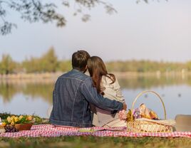 Couple enjoying a picnic while looking at the water