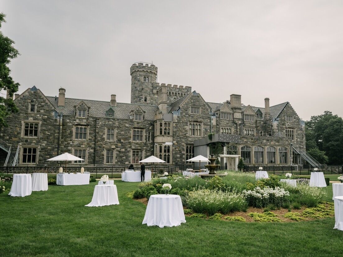 Outside grand stone castle of Sands Point Preserve with outdoor reception space