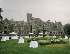 Outside grand stone castle of Sands Point Preserve with outdoor reception space