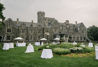 Outside grand stone castle of Sands Point Preserve with outdoor reception space