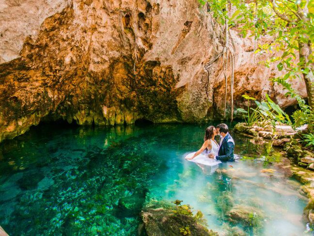 Bride jumping from a cliff into the ocean