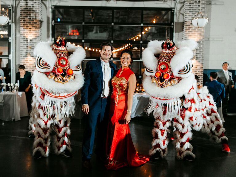 Bride and groom with cultural Chinese lion dancers at wedding reception