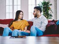 woman and man sitting on couch having a serious conversation