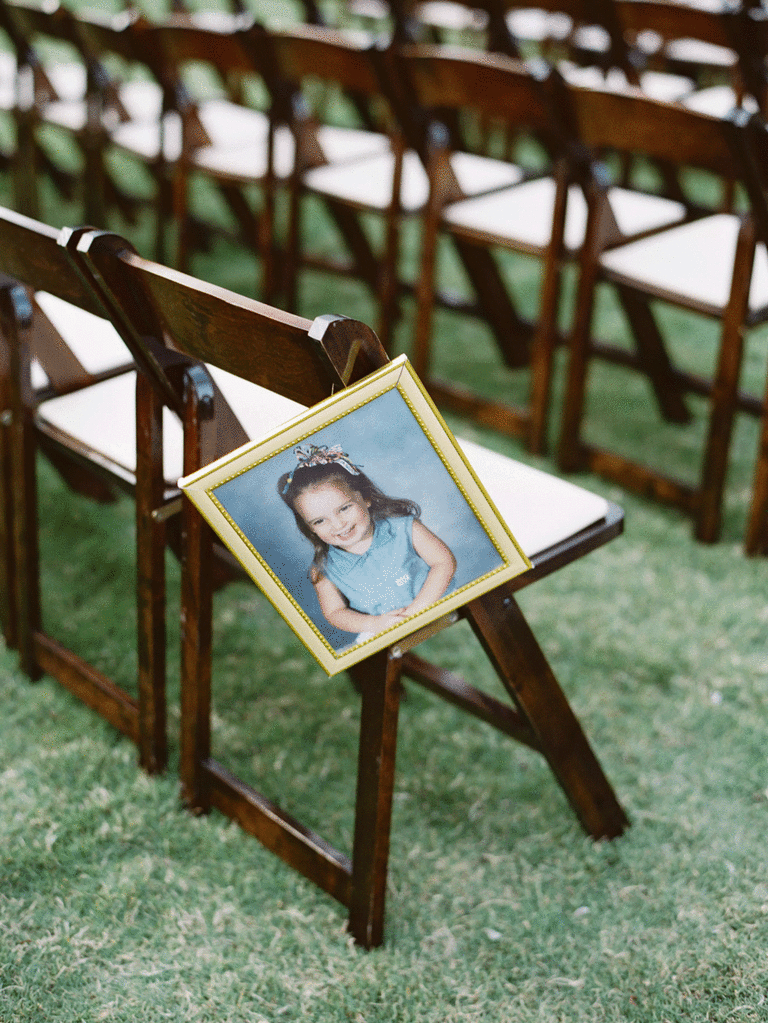 Photo of bride in frame hanging from ceremony chair. 
