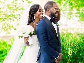 First look between bride in pajamas and groom with wedding party