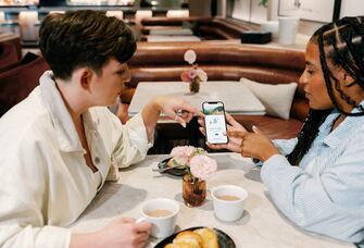 Woman showing her registry website in a cafe