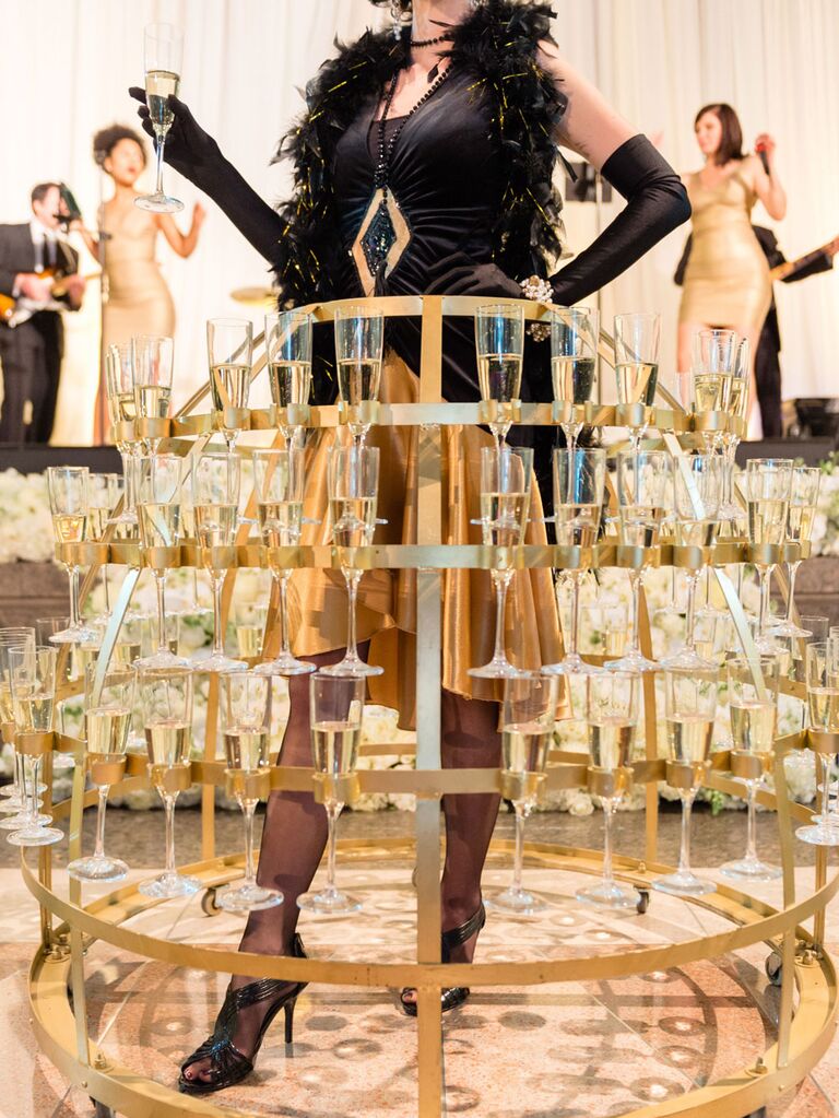 Champagne server at wedding reception with metal skirt holding champagne glasses