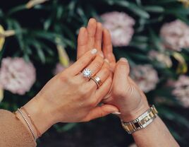 engagement announcement photo with couple holding hands and bride wearing round diamond engagement ring