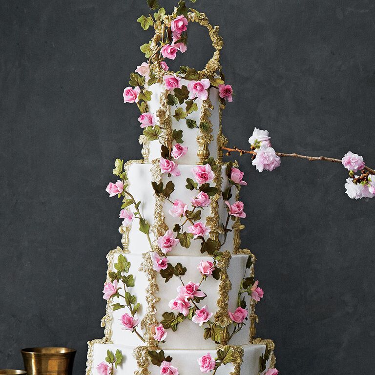 Ornate four-tier wedding cake with pink flowers